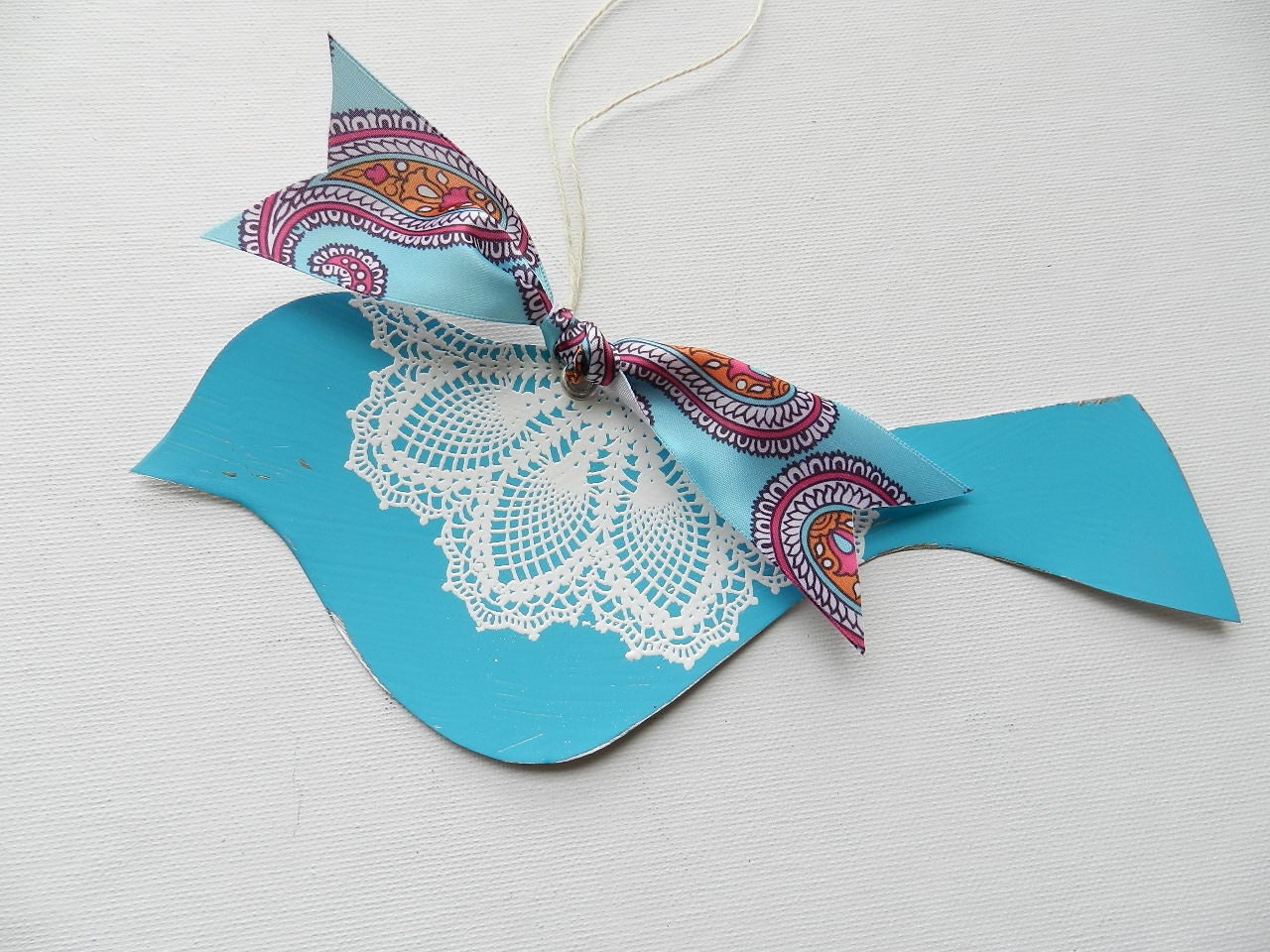 Blue bird with white doily design and colorful paisley ribbon room decor