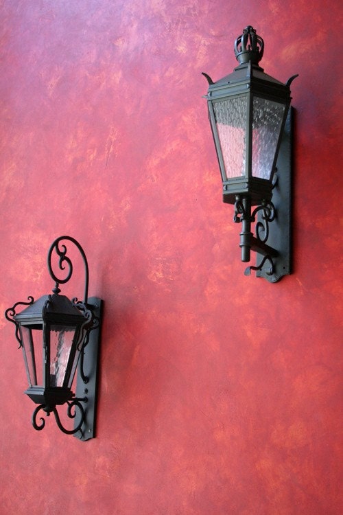 deep red wall and lanterns stucco and iron make a stunning pair