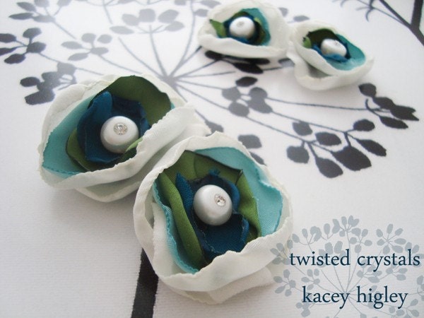 A pair of handmade innocent ivory and something blue flowers filled with a large fresh water pearl and Swarovski crystal. For your wedding, favorite shoes and life.
