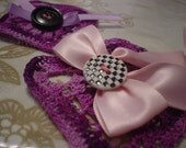 Violet as a pin brooch that has crochet ribbon and buttons