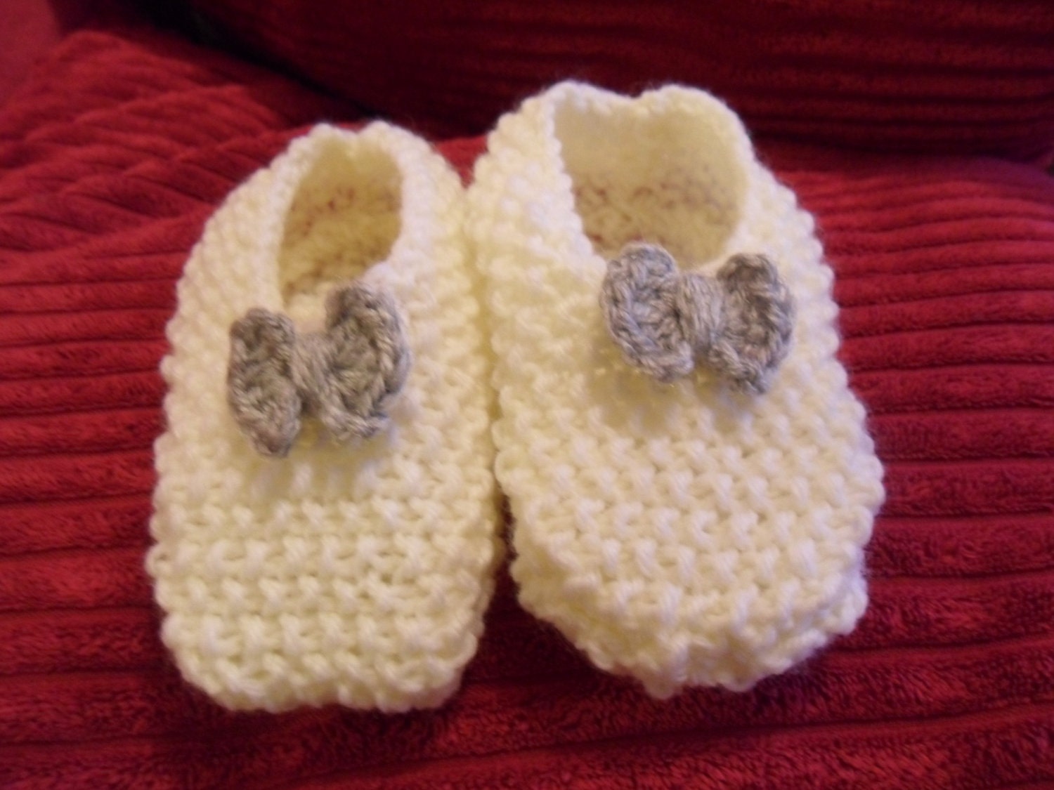 Cream booties with mid-grey bows on the toes
