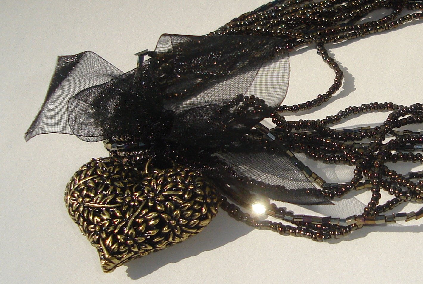 bronze filigree heart pendant on multi strand seed bead necklace in black and bronze with black organza ribbon - Ziporgiabella