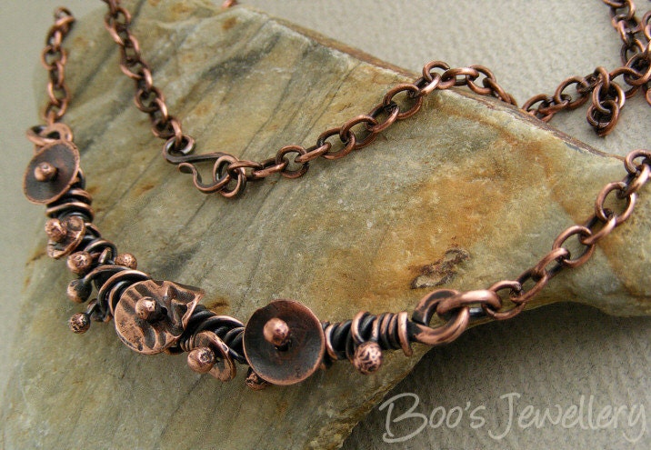 Antiqued copper necklace randomly wrapped with molten buds and simple flower shapes