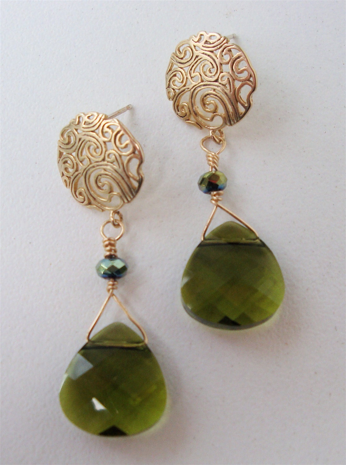 Matte gold vermeil earring with paisley design and sterling silver post with a beautiful olive green colored swarovski crystal briolette. 1
