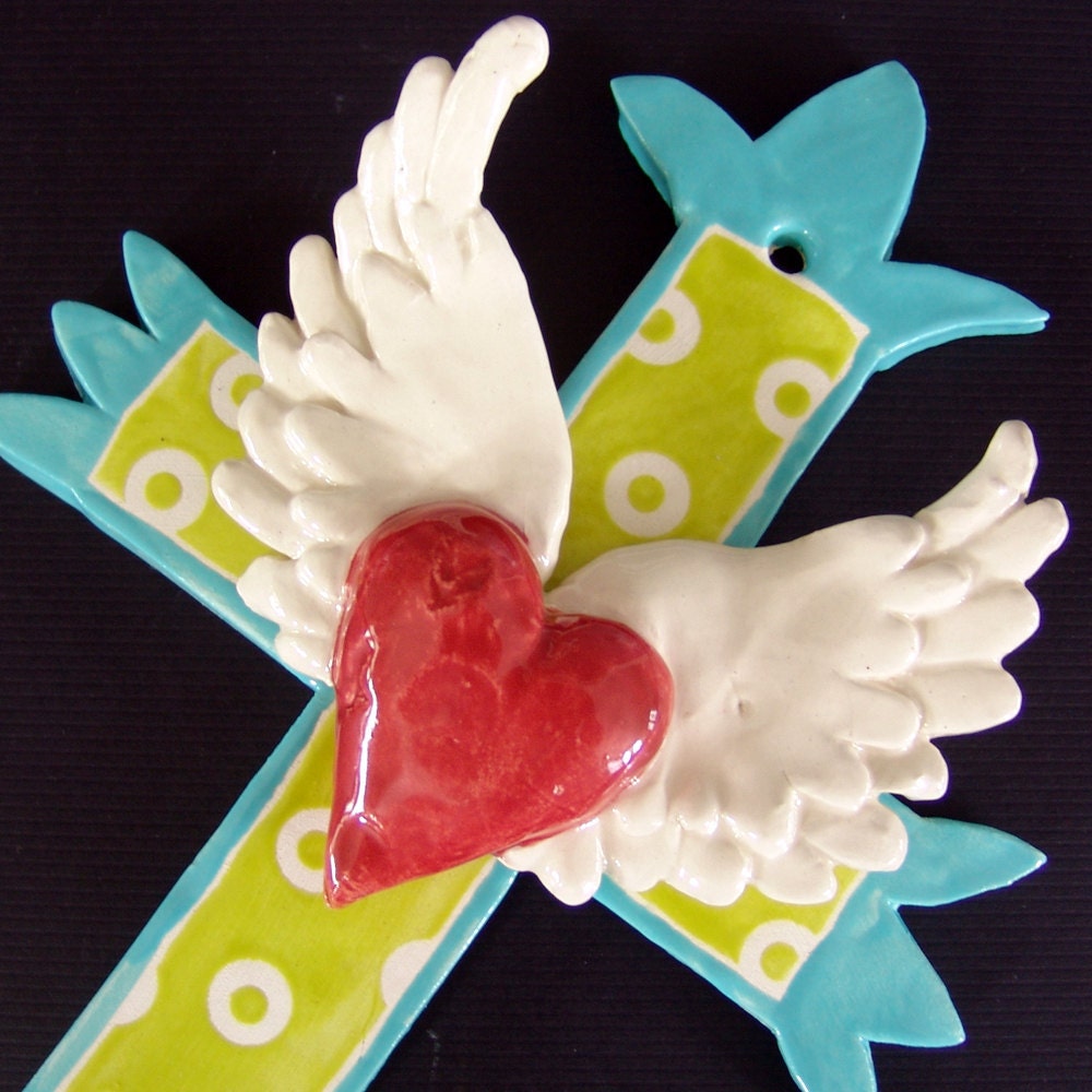 turquoise cross with large winged heart