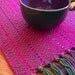 small handwoven table runner in magenta