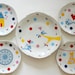 Super festive serving set of one very large and four smaller (cake/breakfast) plates