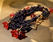 Triple strand nylon chain bracelet with red wire-wrapped flowers