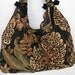 slouchy hobo shoulder bag with faux tortise chain accent in a bold leafy floral print fabric