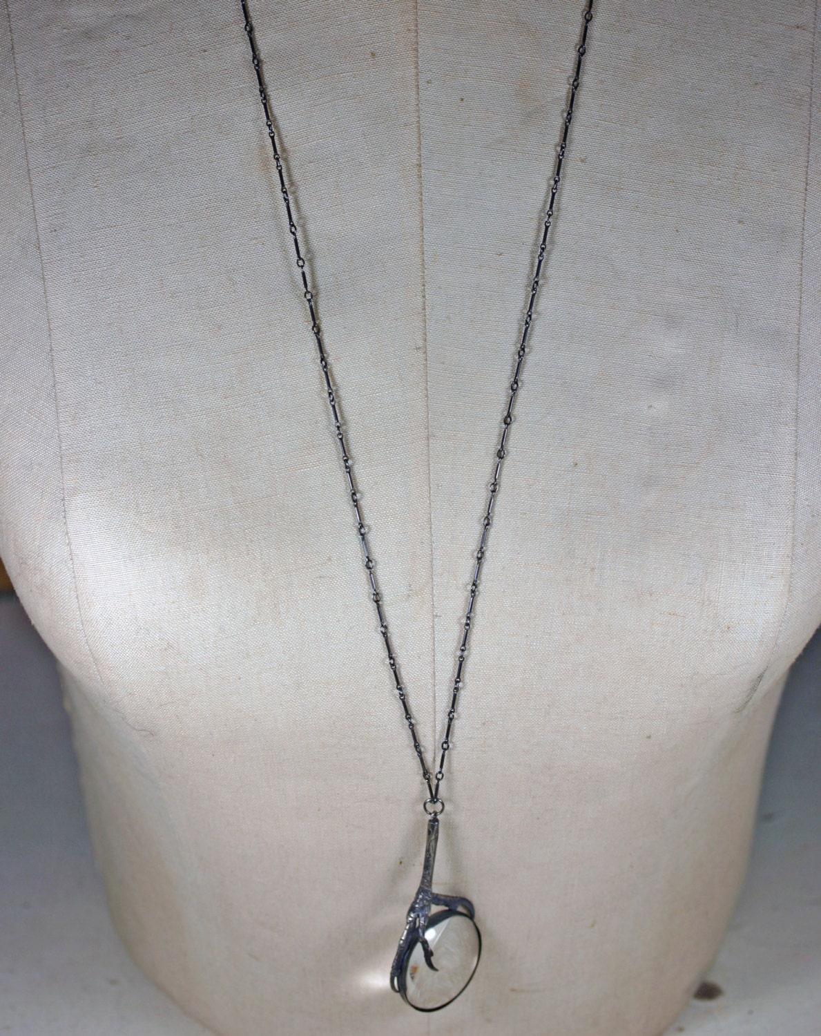 the oracle. magnifying glass and starling claw necklace.