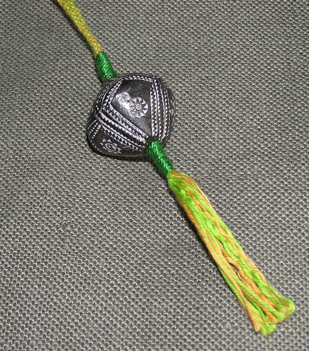 Wristaff - handmade braid with African bead-whorl