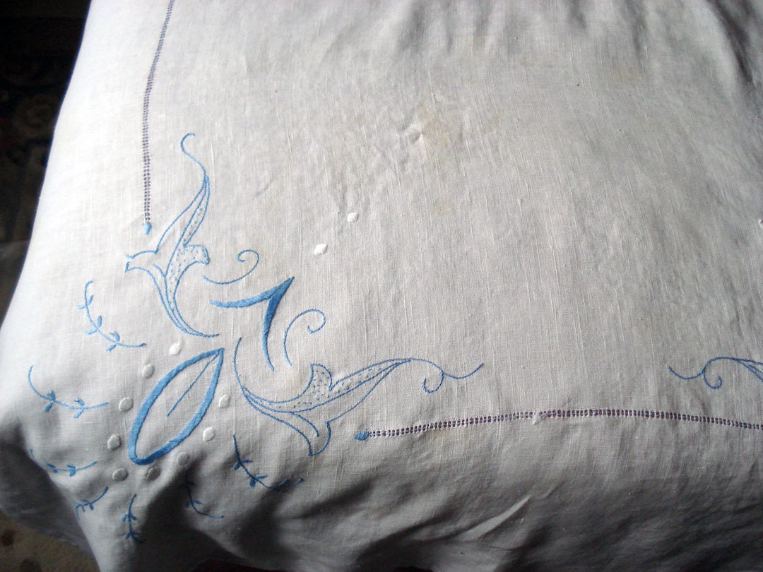 White linen tablecloth with light blue embroidery and openwork