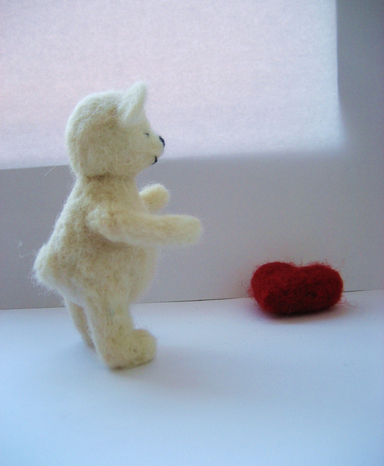 Woolly the shy Ted. Needlefelted white teddy bear with red heart.