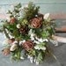 Bridal bouquet made with fresh evergreens and pine cones with birch handle. For your winter woodland natural wedding.