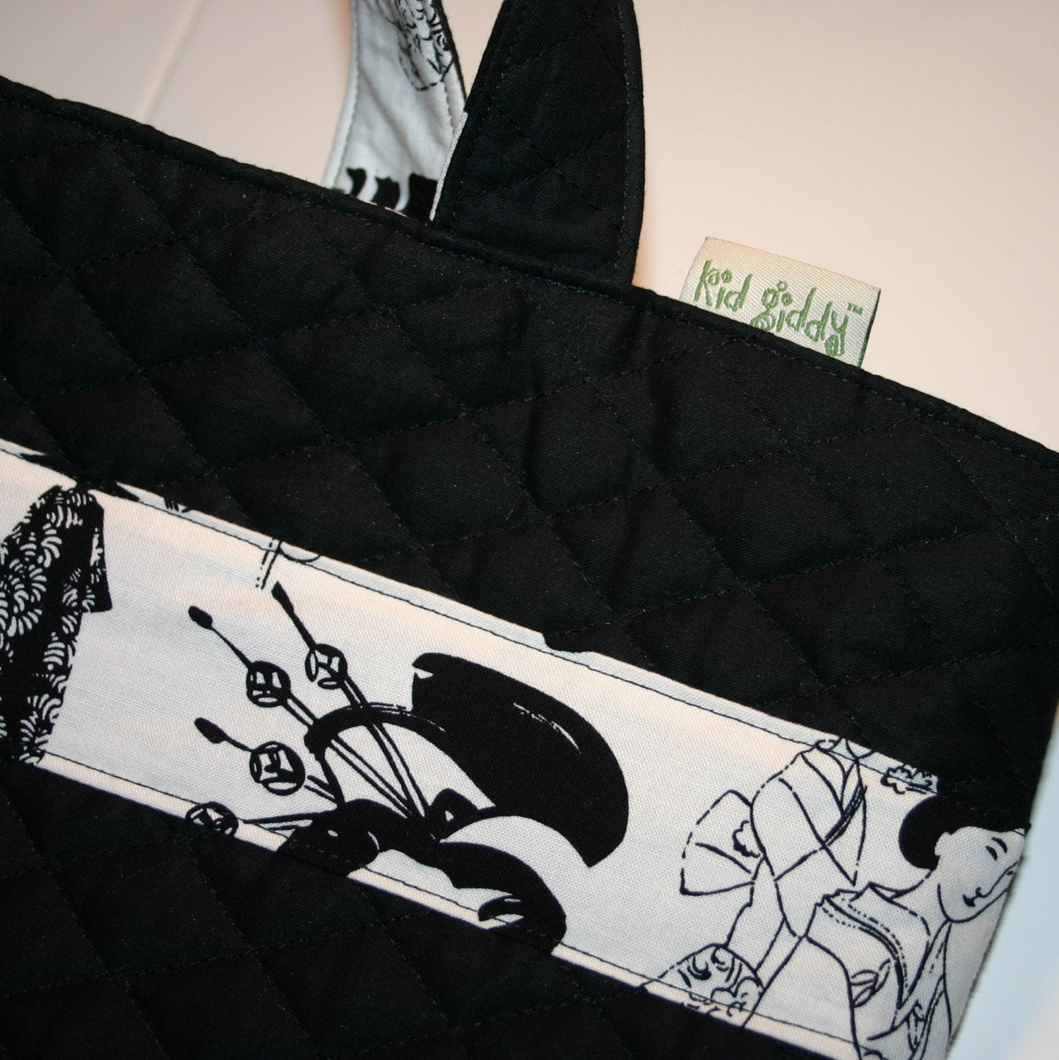 The AMY Reversible Tote Bag Black Quilted outer with Geisha Silhouette Asian inspired fabric lining and stripe on Exterior