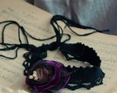 Black choker with flower brooch in black, brown and purple.