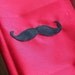 Add a felt mustache to any tie onesie