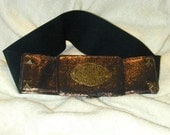 Dramatic bronzed leather buckle on wide cinch belt