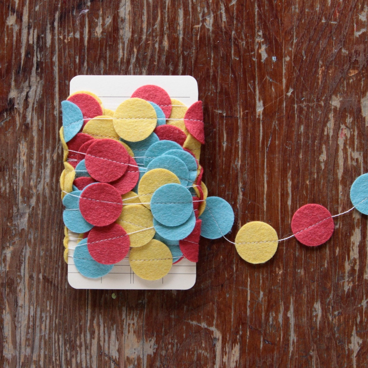 Garland of Felt Fanfare in Carousel Colors: Strawberry Red, Ochre Yellow and Swan Blue