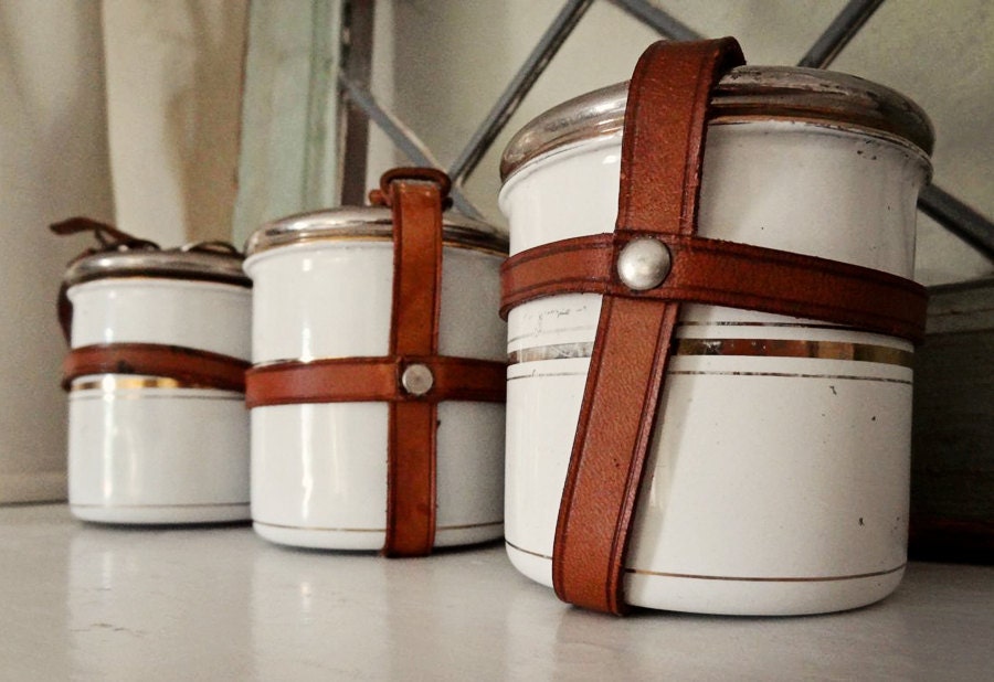 vintage enamelware canisters, 3 small tins with leather straps, white with gold striping from Germany