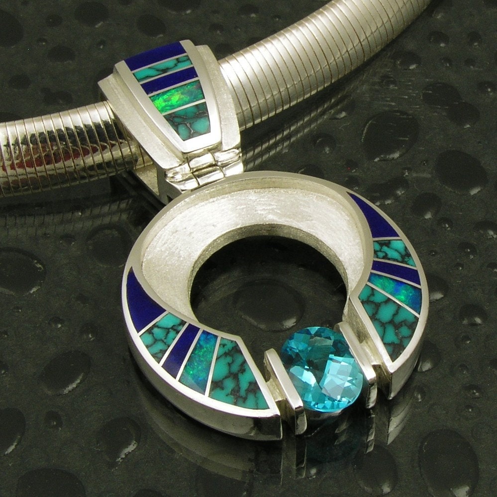 Sterling silver pendant inlaid with turquoise, lapis and opal and accented by a 2 ct. topaz.