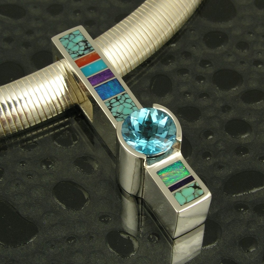 Sterling silver pendant inlaid with turquoise, opal, sugilite and coral.