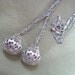 Long silver tone triple strand necklace with textured teardrop beads