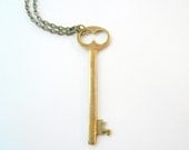 Long skeleton key necklace of antiqued brass on long chain. Owl eyes.