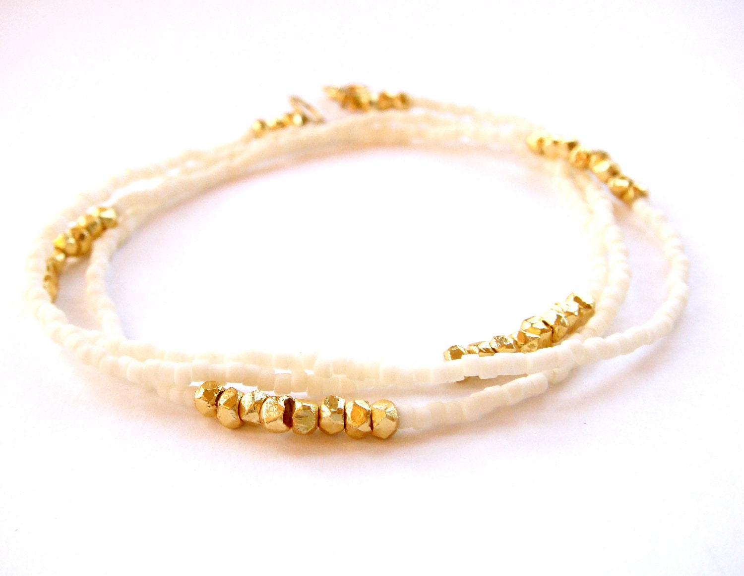 holocene // bracelet / necklace with mini geometric gold beads on background of ivory seed beads