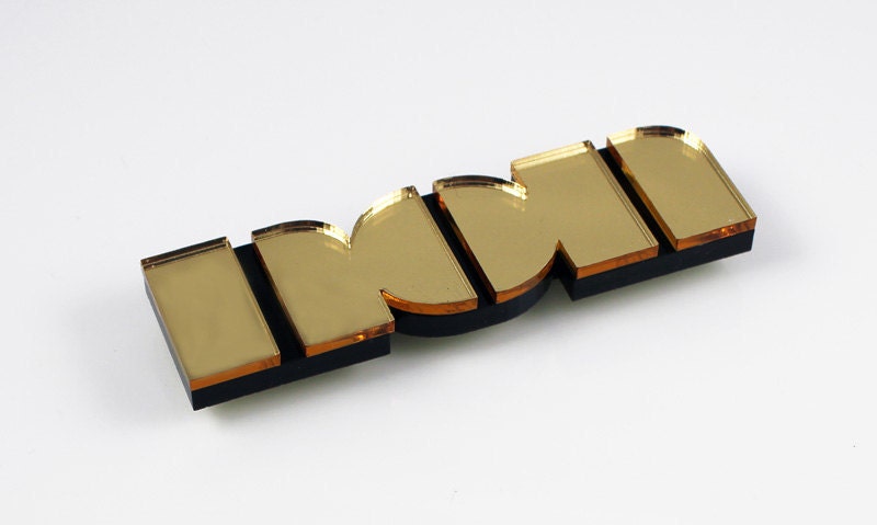 Non brooch in gold mirror perspex
