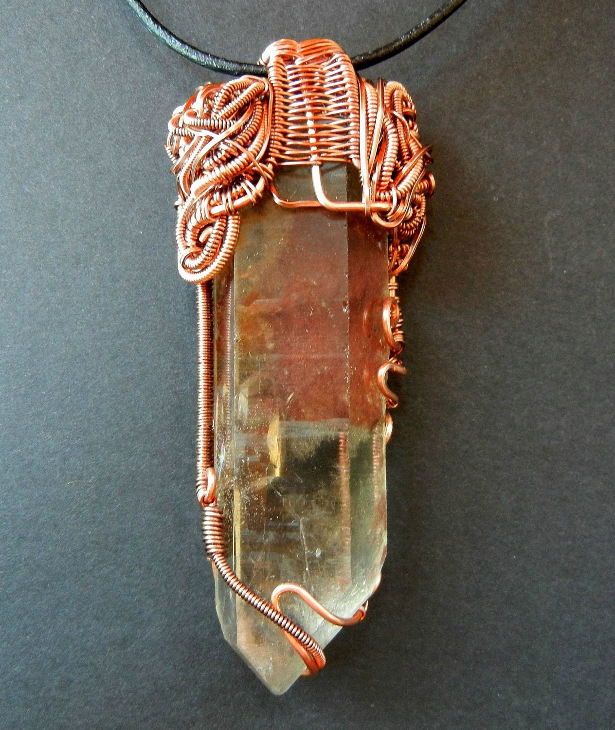 Copper wire wrapped large quartz crystal with ferrous inclusions