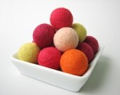 A pile of 14 round felted wool beads (lemon, apricot, orange, amaranth, rose)