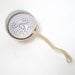 Beautiful tea strainer  with curled grip with a fitting bowl