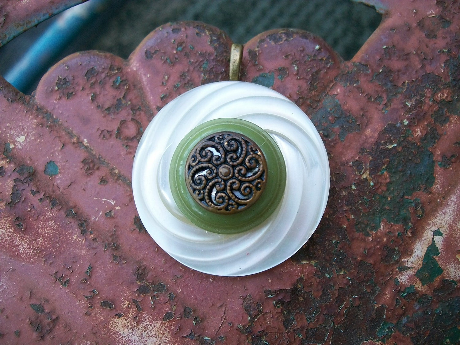 vintage button pendant necklace jewelry plastic faux mother of pearl swirl base green middle and gold metal Victorian mirrored swirl center