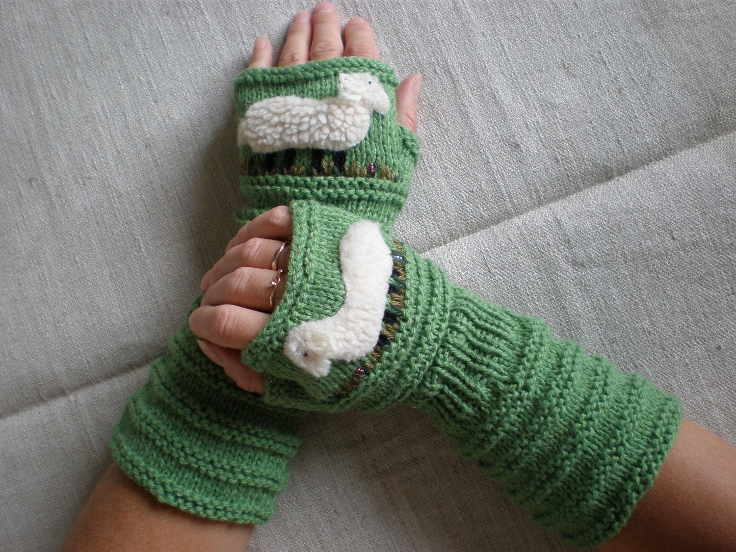 Hand-knitted green wrist warmers with hand needlecrafted sheep