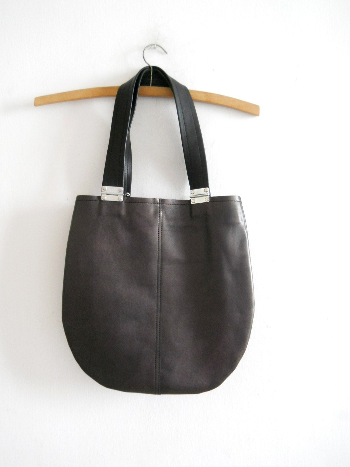 Dark purple leather bag with black strips and hinges