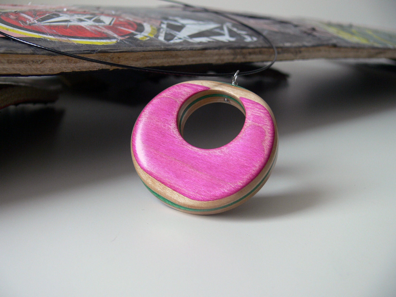 pink recycled wood reversable pendant on a wire necklace