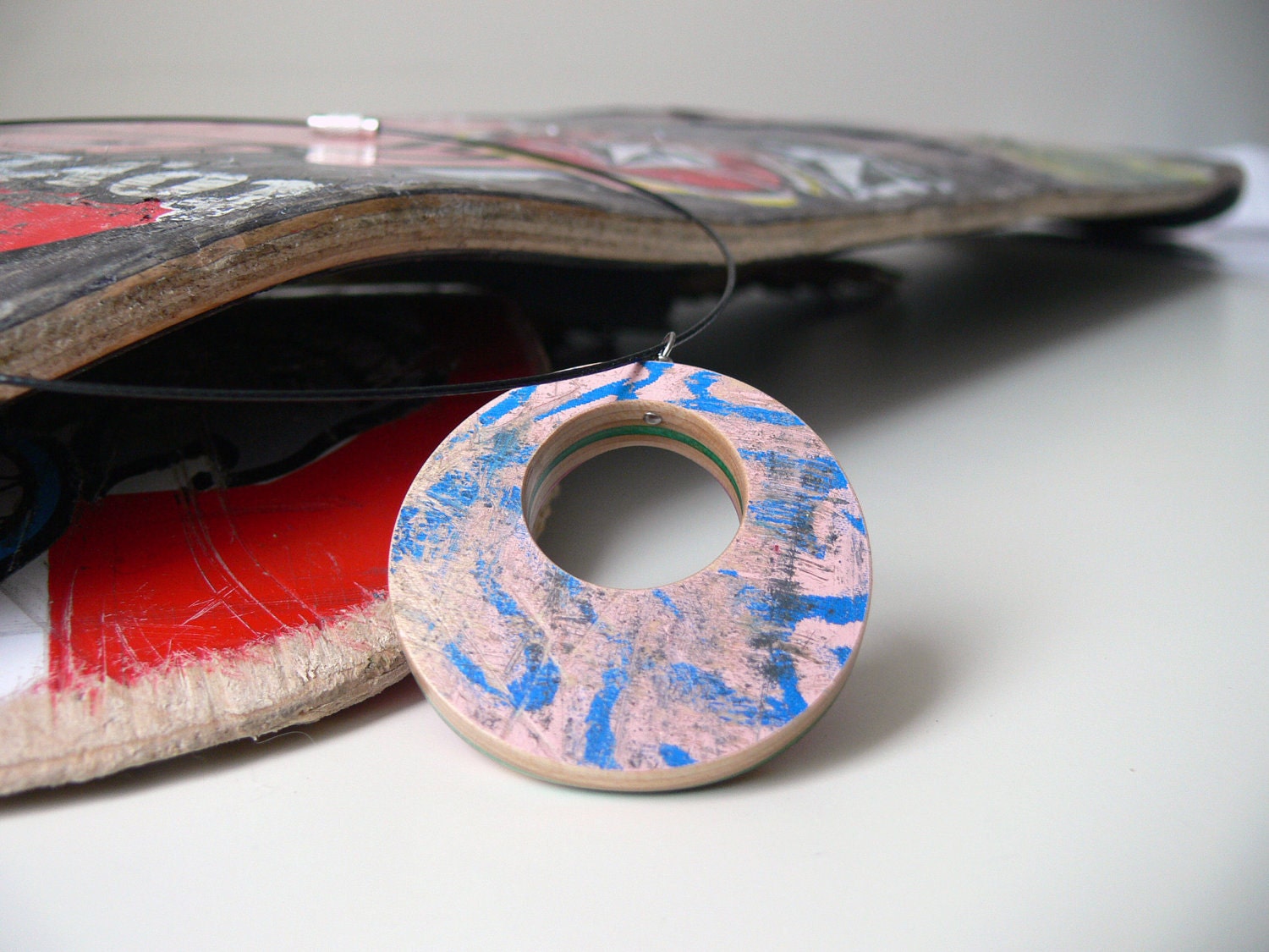 pink recycled wood reversable pendant on a wire necklace