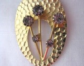 Gold tone hammered oval pin brooch with purple rhinestone floral spray. Vintage brooch. Vintage pin