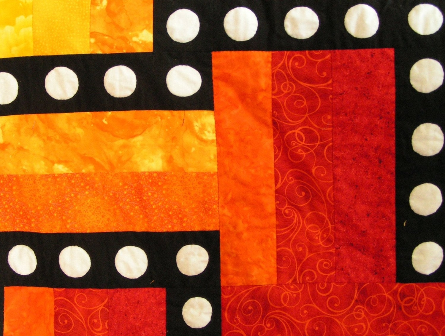 Quilt--Hot Colors of Yellow, Orange, Red and Pink Form the Background for a Black Maze with White Appliqued Circles