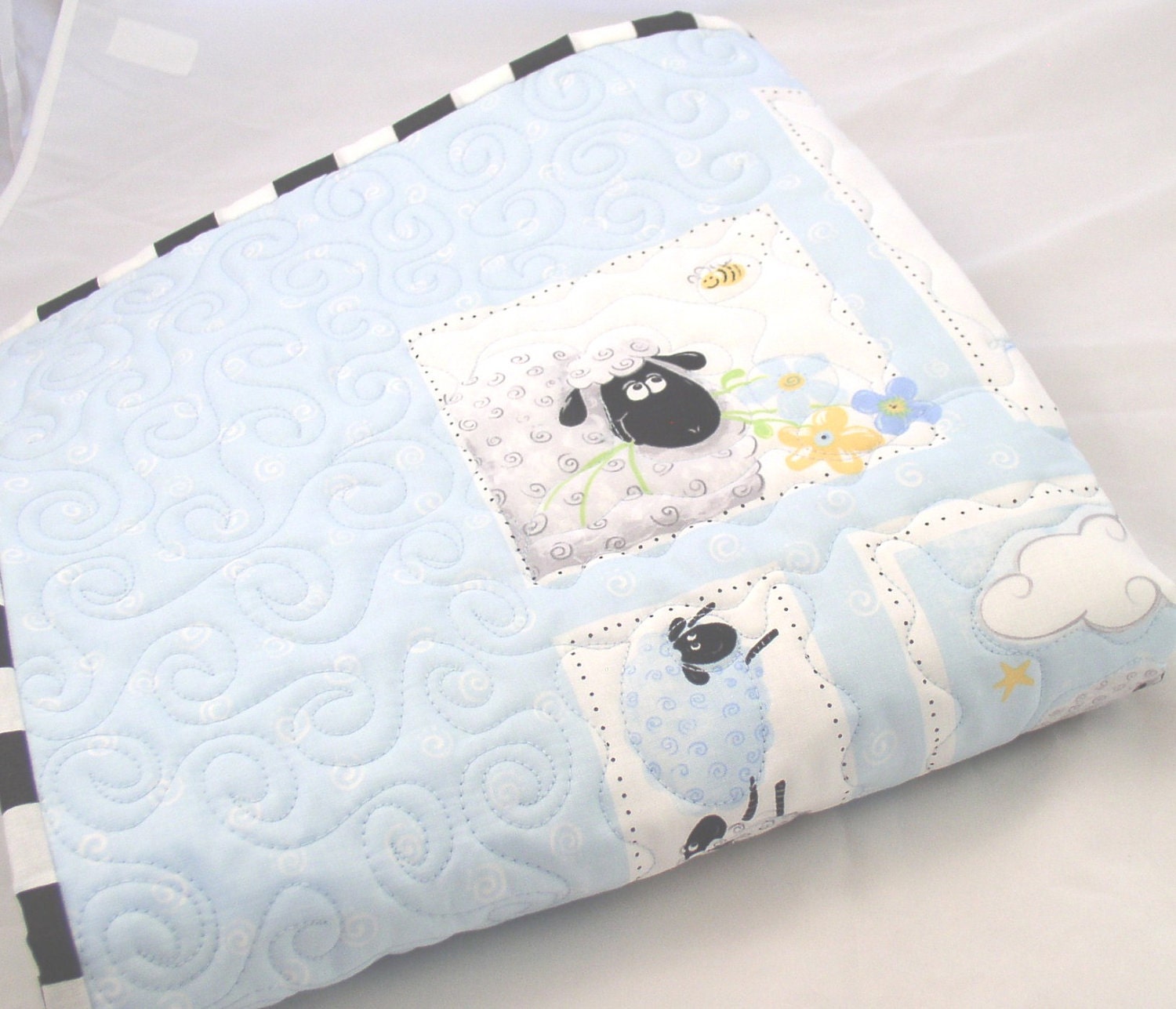 Black and White Sheep Adorn a Pale Blue Baby Quilt