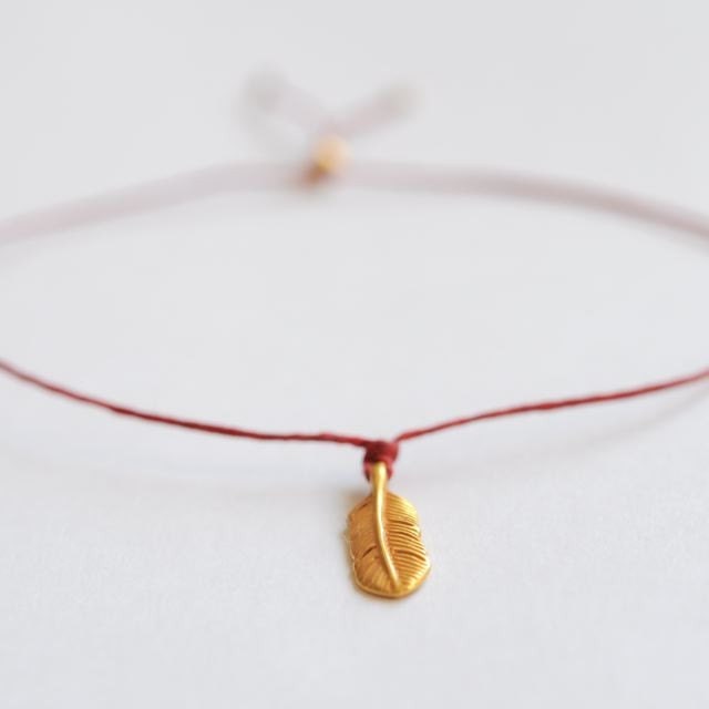 Gold Wish bracelet . Cutest gold feather charm red irish waxed linen cord