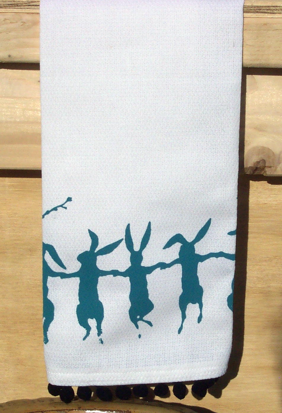 Cotton huck tea towel with teal dancing rabbits screen print pom pom trim