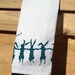 Cotton huck tea towel with teal dancing rabbits screen print pom pom trim