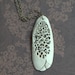 Delicate decay. An earthy porcelain pendant with pitted texture.