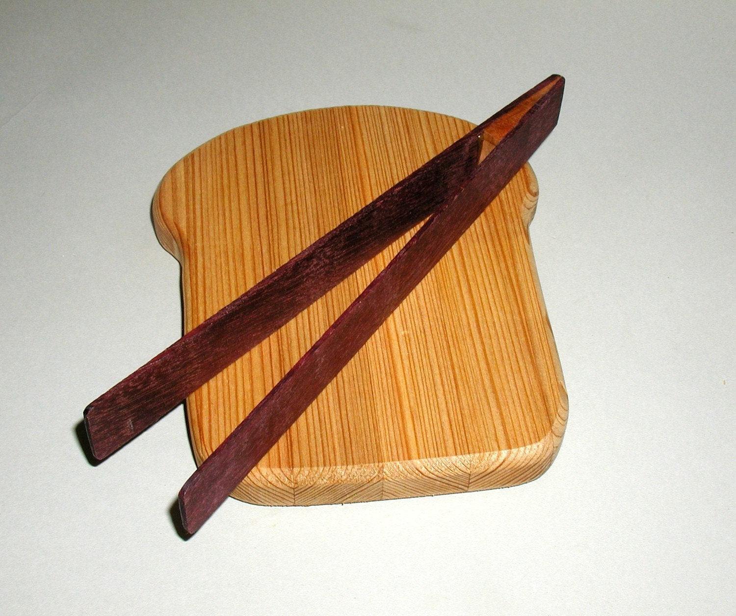 slice of bread board and toast tongs