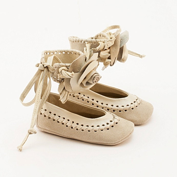 Beige leather baby shoes made from braided leather and embellished with a rose