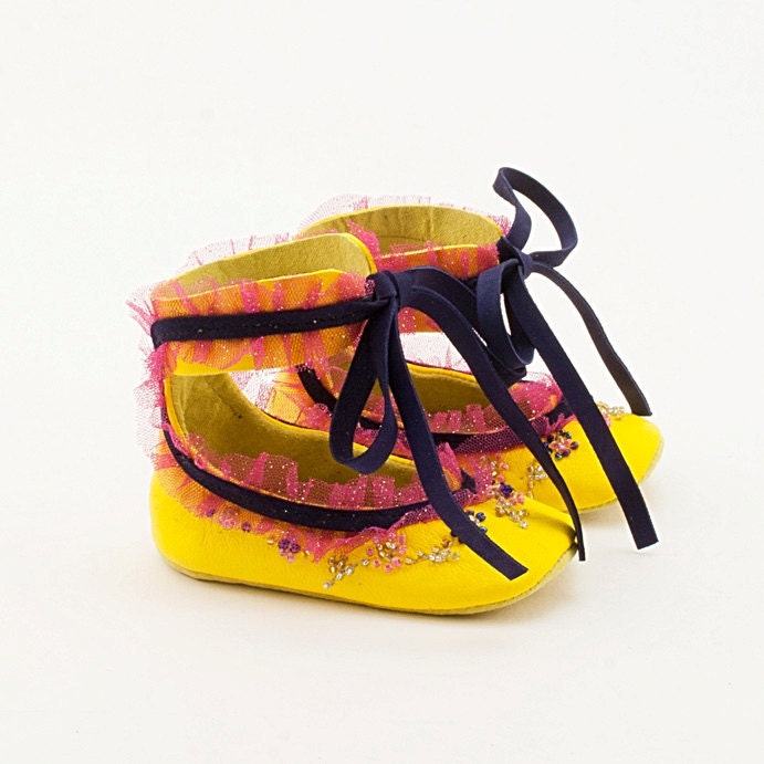 Yellow leather baby shoes with hand-embroidered flowers and lace edging