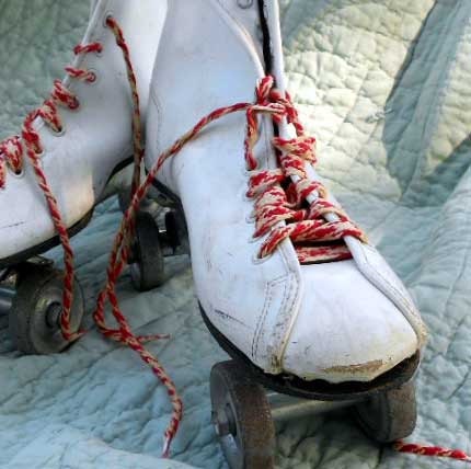 Vintage Roller Derby skates from the 1960s with metal wheels and red and white laces, size 7