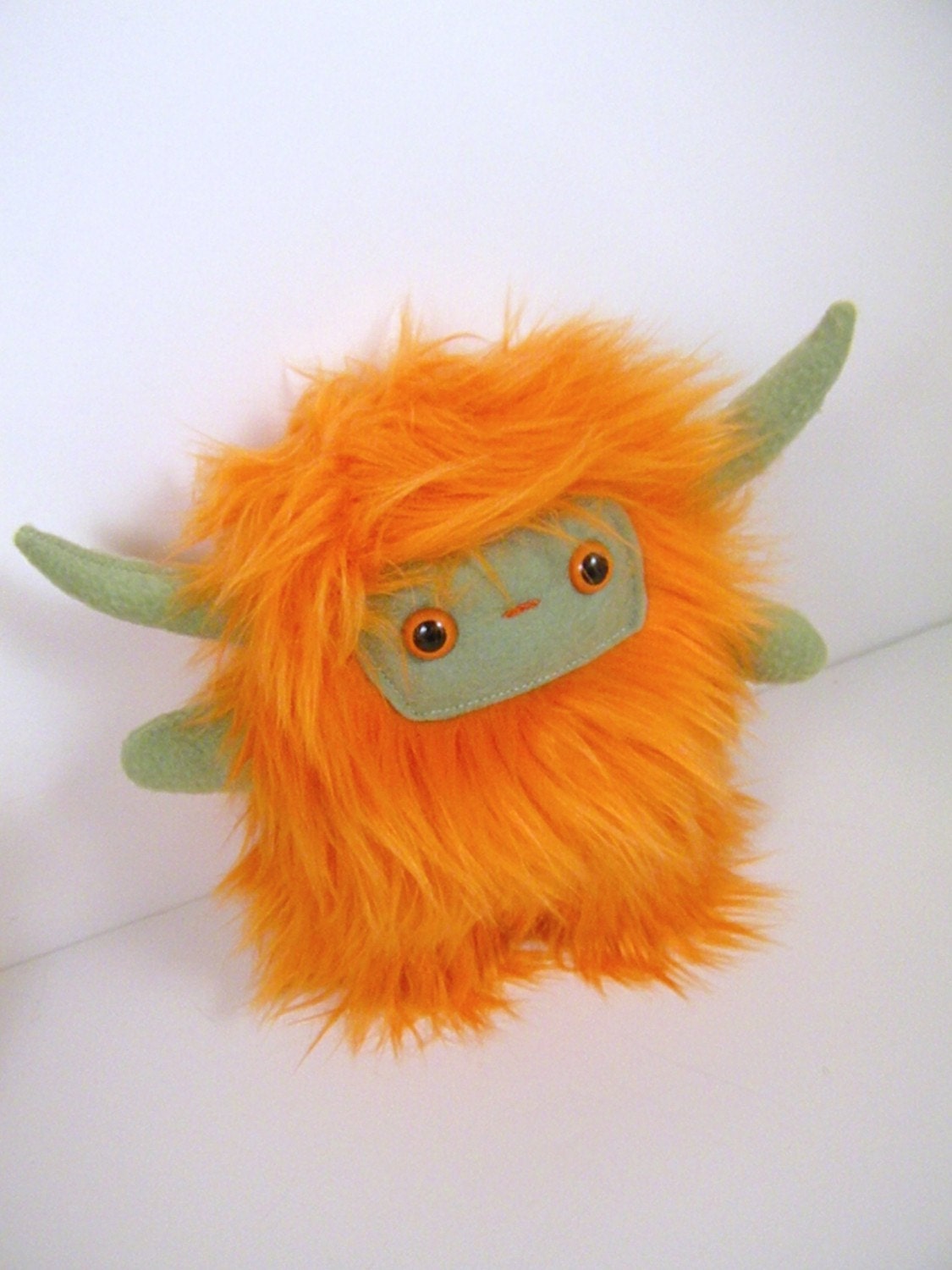 Nin the horned plush monster orange and olive green stuffed animal